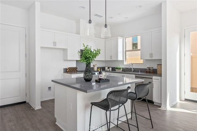 kitchen featuring sink, hanging light fixtures, dishwasher, a kitchen island, and white cabinets