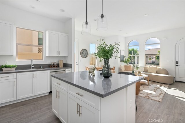 kitchen with pendant lighting, sink, white cabinetry, and stainless steel dishwasher