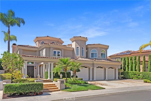 mediterranean / spanish house with concrete driveway and stucco siding