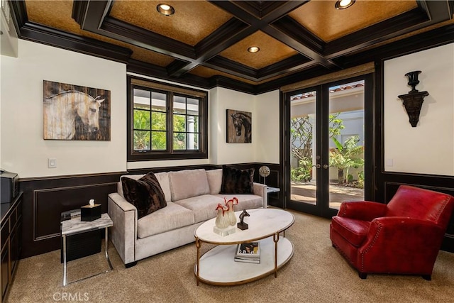 living room with beamed ceiling, coffered ceiling, ornamental molding, light carpet, and french doors