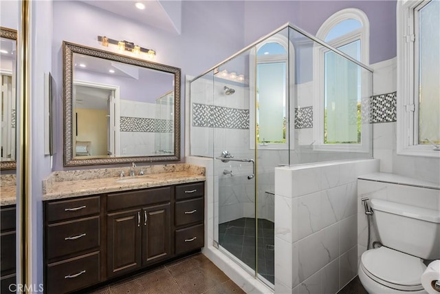 bathroom with toilet, tile patterned floors, a shower with shower door, and vanity