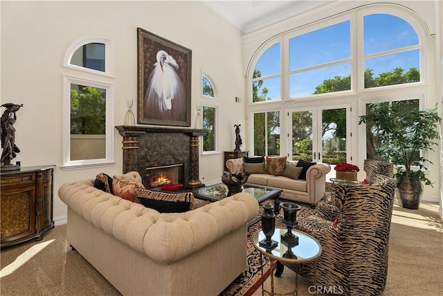 carpeted living room featuring a high ceiling, french doors, and a fireplace