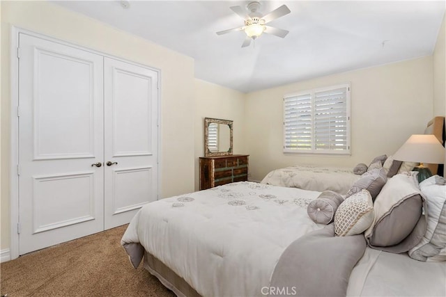 carpeted bedroom with ceiling fan and a closet