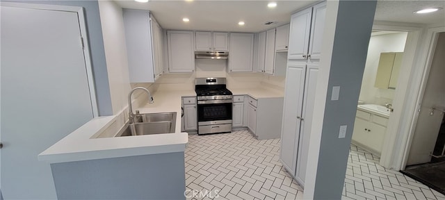 kitchen with white cabinetry, stainless steel gas range oven, light tile patterned floors, and sink