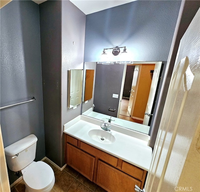 bathroom featuring vanity, toilet, and tile patterned floors