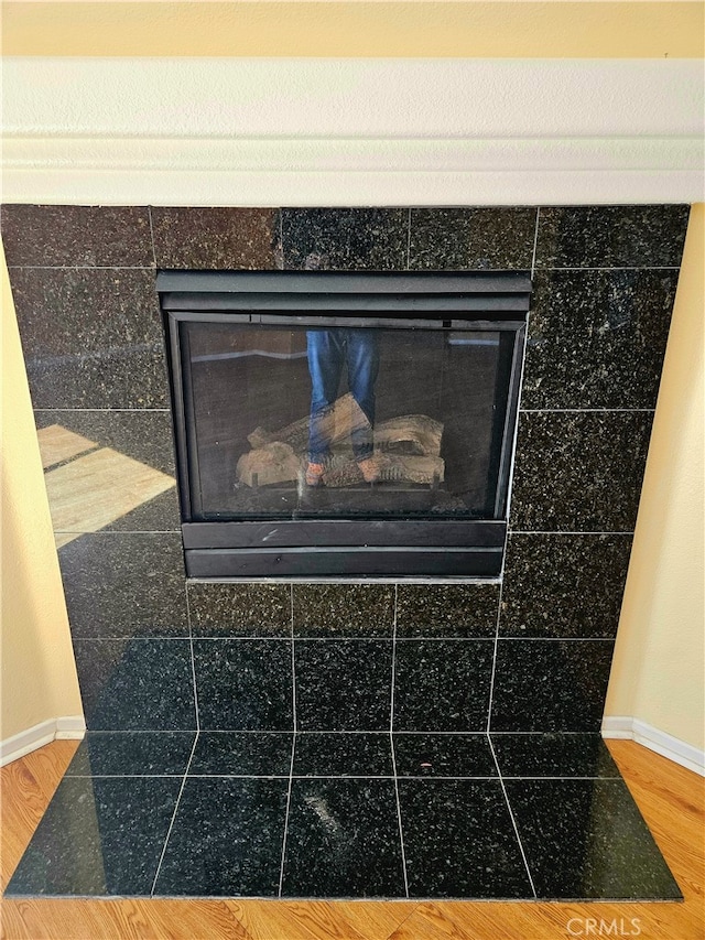 room details with hardwood / wood-style flooring and a tile fireplace