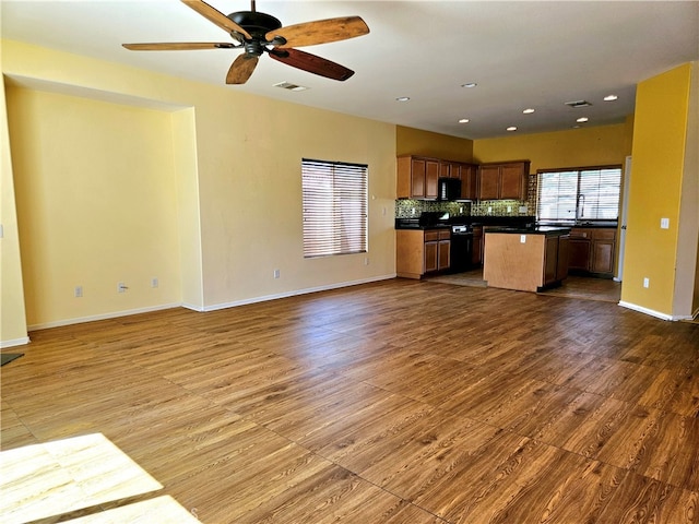 kitchen featuring range, decorative backsplash, a kitchen island, and hardwood / wood-style floors