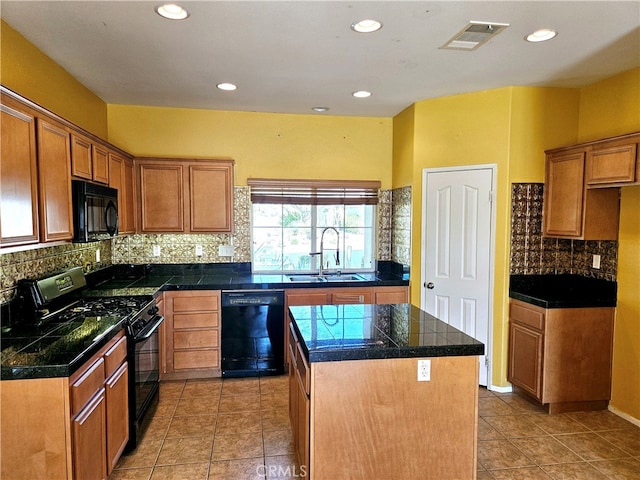 kitchen with backsplash, black appliances, sink, and a kitchen island