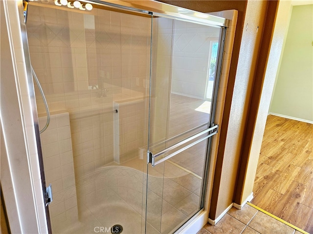 bathroom featuring wood-type flooring and an enclosed shower