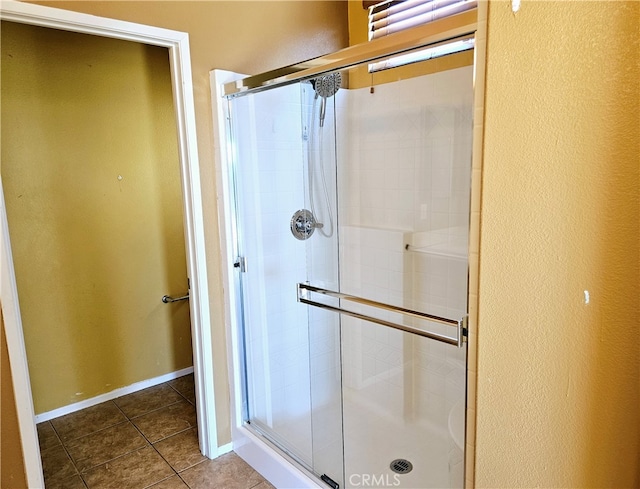 bathroom with walk in shower and tile patterned flooring