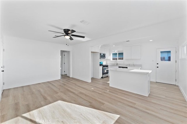 kitchen with a center island, light hardwood / wood-style floors, white cabinetry, and stainless steel appliances