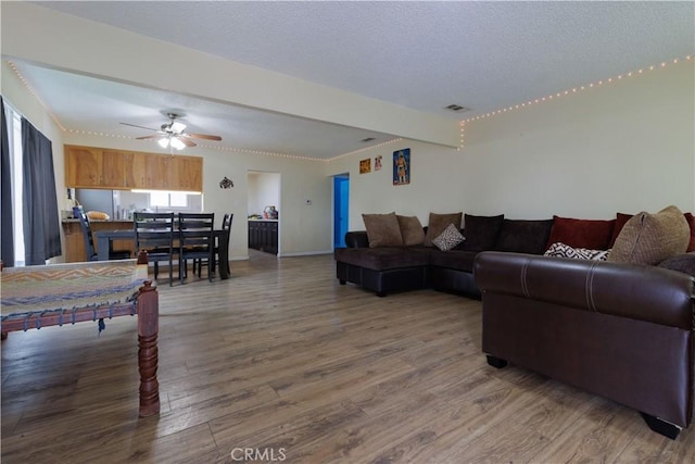 3604 Campbell St, Jurupa Valley, CA 92509 - living area featuring wood finished floors, ceiling fan, a textured ceiling, beam ceiling, and baseboards