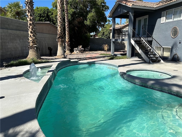 view of pool with a patio, an in ground hot tub, and pool water feature