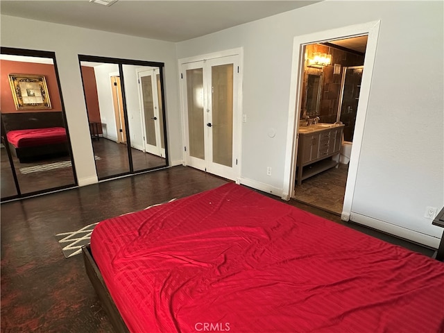 bedroom featuring french doors, two closets, ensuite bath, and sink