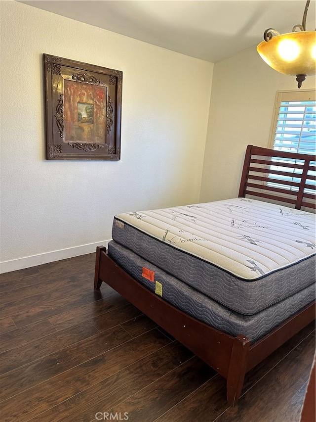 bedroom with dark hardwood / wood-style flooring