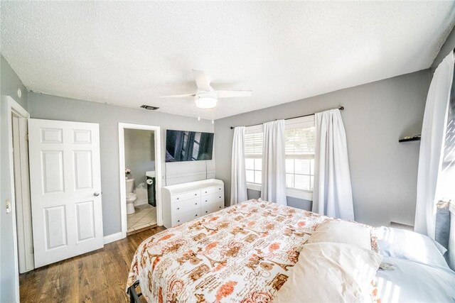 bedroom featuring a textured ceiling, ceiling fan, ensuite bathroom, and dark hardwood / wood-style floors