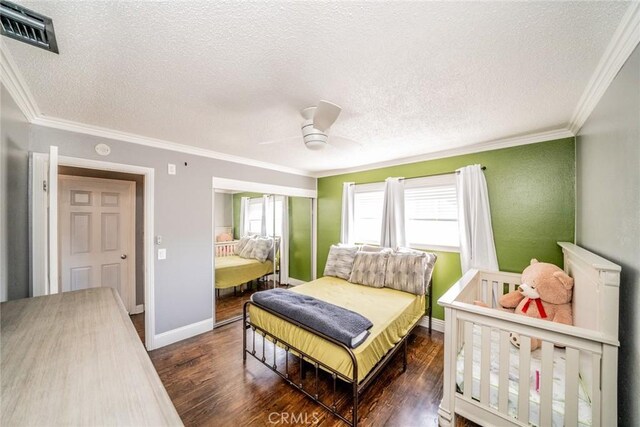 bedroom featuring ceiling fan, dark hardwood / wood-style flooring, crown molding, and a textured ceiling