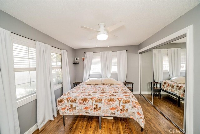 bedroom with hardwood / wood-style floors, ceiling fan, and a closet