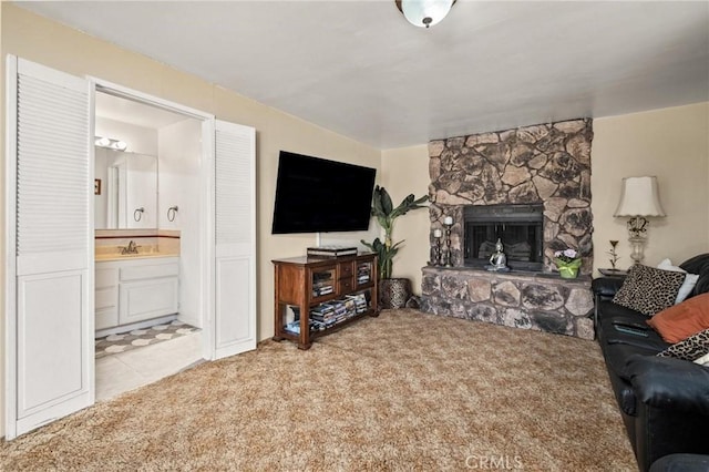 carpeted living room featuring a fireplace and sink