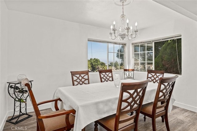 dining area with wood-type flooring and a notable chandelier