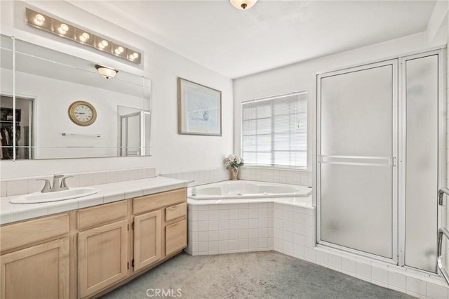 bathroom featuring vanity and independent shower and bath