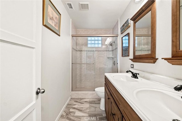 bathroom featuring vanity, toilet, and a shower with shower door