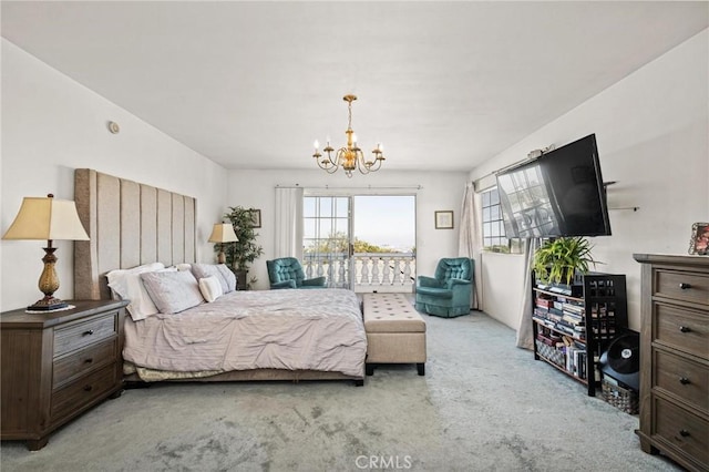 carpeted bedroom featuring access to exterior and a notable chandelier