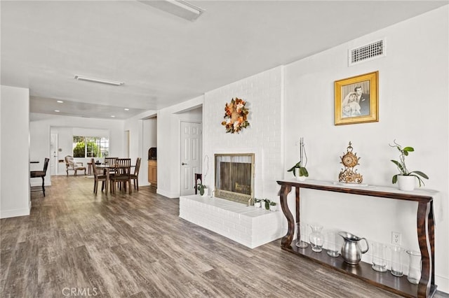 living room featuring hardwood / wood-style floors and a brick fireplace