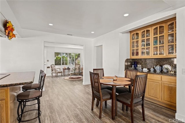 dining area with dark hardwood / wood-style flooring and bar