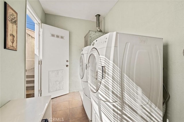 laundry area featuring light tile patterned flooring and washing machine and clothes dryer