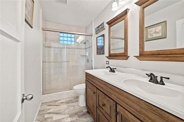 bathroom with toilet, vanity, and walk in shower