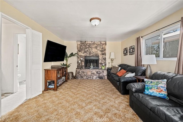 living room featuring a stone fireplace and carpet floors