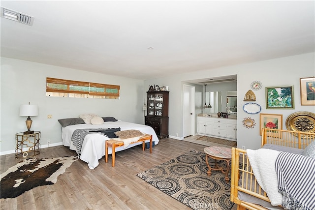 bedroom featuring hardwood / wood-style flooring and ensuite bathroom