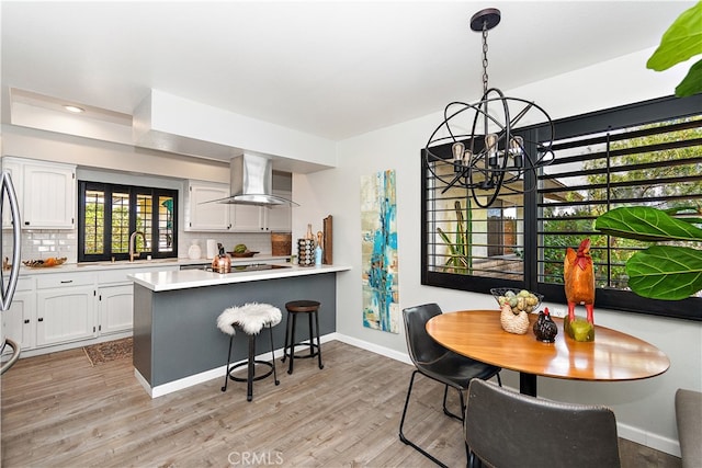 dining space featuring a notable chandelier, light hardwood / wood-style floors, and sink