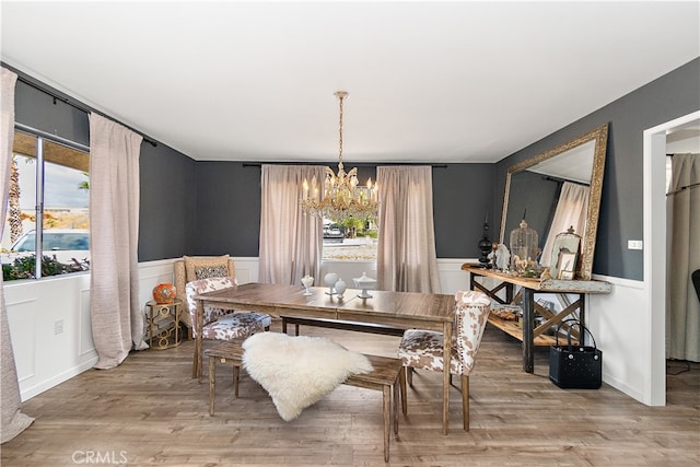 dining room featuring light wood-type flooring and an inviting chandelier