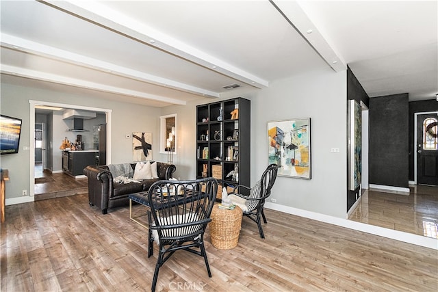 living room with wood-type flooring and beam ceiling