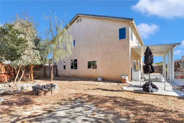 rear view of house featuring a patio and a fire pit