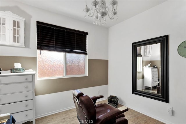 sitting room featuring light wood-type flooring and an inviting chandelier