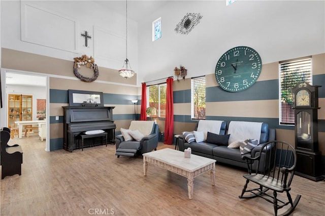 living room featuring a towering ceiling and hardwood / wood-style flooring