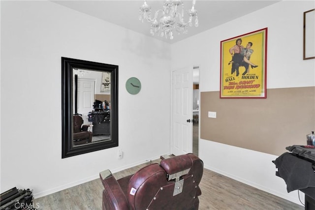 misc room with hardwood / wood-style flooring and an inviting chandelier