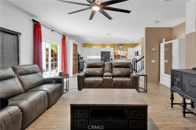 living room with ceiling fan and light hardwood / wood-style flooring