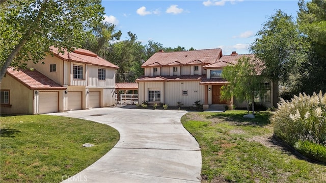 mediterranean / spanish house featuring a front yard and a garage