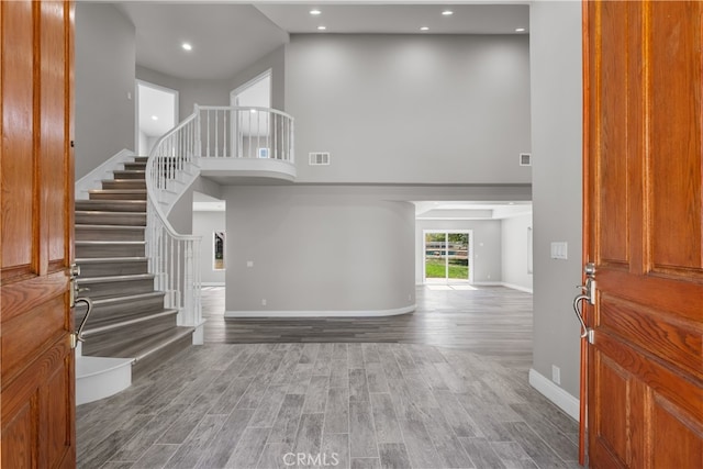 entrance foyer featuring a towering ceiling and hardwood / wood-style floors