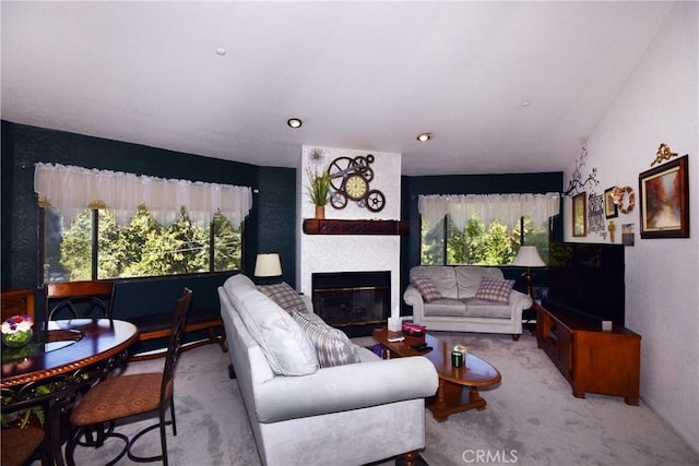 carpeted living area with a large fireplace