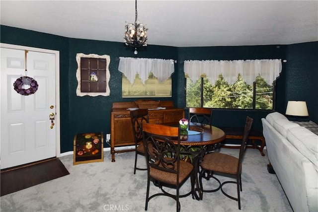 carpeted dining room with a notable chandelier and baseboards