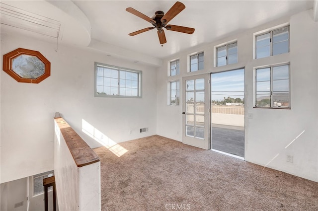 carpeted spare room with ceiling fan and a wealth of natural light