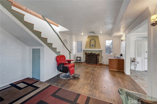 entryway featuring beamed ceiling, a fireplace, and hardwood / wood-style floors