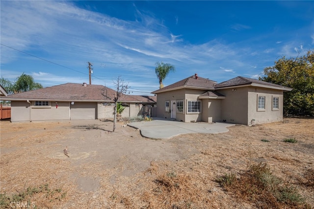 back of property with a patio and a garage