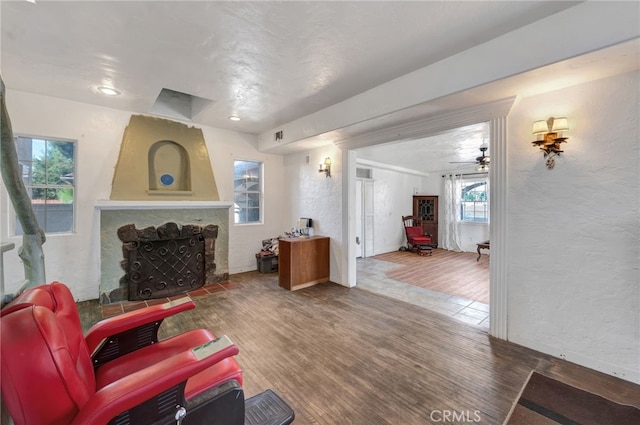 living room featuring a fireplace, hardwood / wood-style flooring, and ceiling fan