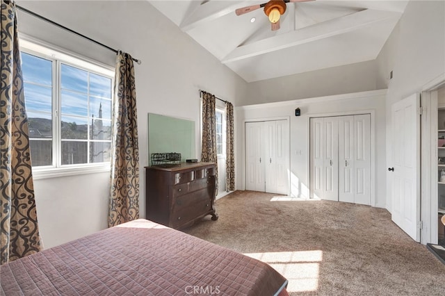 bedroom with multiple closets, ceiling fan, beamed ceiling, high vaulted ceiling, and carpet